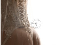 Romantische en intieme fotoshoot van een bruid in een witte zijden jurk, vastgelegd in een luxe boudoir setting.