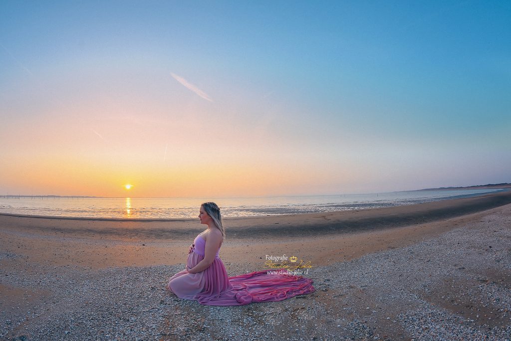 Zwangerschapsfotoshoot op het strand met zonsondergang. De mooiste unieke magische zwangerschapsfoto